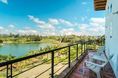 a balcony with two chairs and a view of a lake at La Villa, Espectaculares vistas al lago Peñol-Guatape in Guatapé