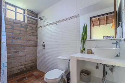 a bathroom with a white toilet and a sink at La Villa, Espectaculares vistas al lago Peñol-Guatape in Guatapé