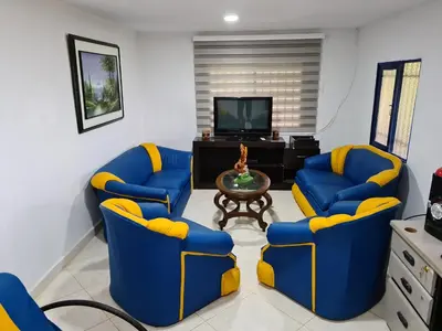 a living room with two blue chairs and a table at Finca Hotel Alto la María in Angelópolis