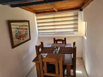 a dining room with a table and chairs and a window at Finca Hotel Alto la María in Angelópolis