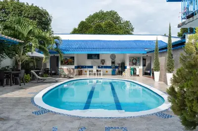 a swimming pool in front of a house at Casa Hotel Victoria Real in Mariquita