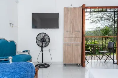 a bedroom with a fan and a dresser with a television at Casa Hotel Victoria Real in Mariquita