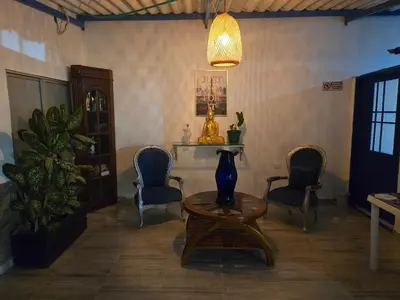a living room with chairs and a table and a lamp at Casa Hotel Victoria Real in Mariquita