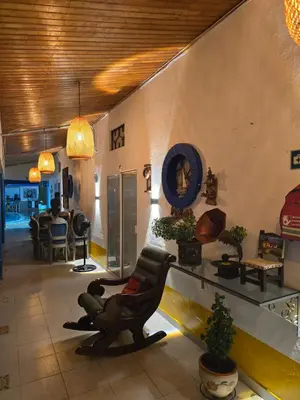 a living room with a chair and a table at Casa Hotel Victoria Real in Mariquita