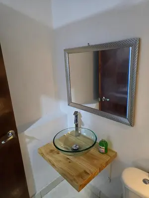 a bathroom with a glass sink and a mirror at Casa Hotel Victoria Real in Mariquita