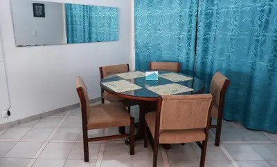 a dining room table with chairs and a blue curtain at Casa La Palma Habitación Cielo in Medellín