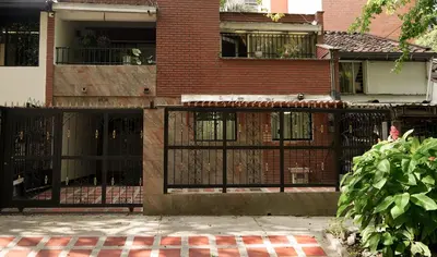 a black fence in front of a brick building at Casa La Palma Habitación Cielo in Medellín