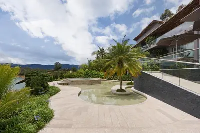 a walkway in front of a building with a palm tree at Tau House in Guatapé