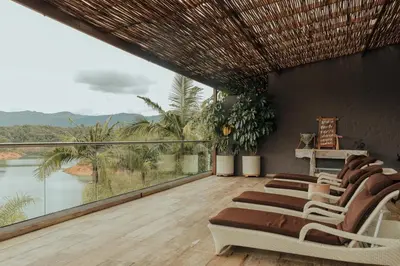 a balcony with chairs and a view of the water at Tau House in Guatapé