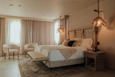 a bedroom with a large bed and a chair at Tau House in Guatapé