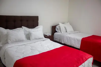 a bedroom with two beds and a red blanket at El Edén hotel Campestre in Pensilvania