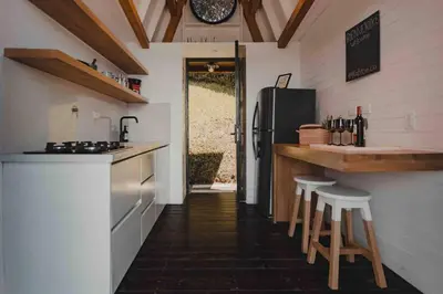 a kitchen with a refrigerator and some bar stools at KABINE in El Peñol