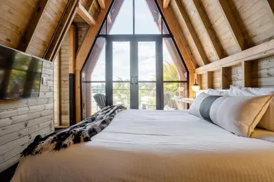 a large bed in a room with a large window at KABINE in El Peñol