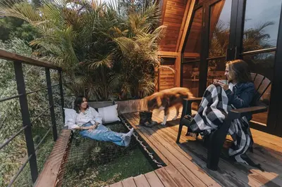 two women sitting on a porch with a dog at KABINE in El Peñol