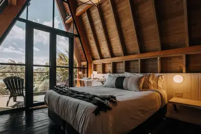 a bedroom with a large bed in a room with windows at KABINE in El Peñol