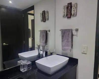 a bathroom with a white sink and a mirror at Center City Flats - Apartments in El Poblado near Park Lleras, Medellin! in Medellín
