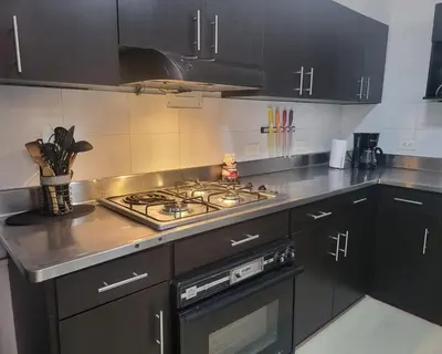 a kitchen with black cabinets and a stove top oven at Center City Flats - Apartments in El Poblado near Park Lleras, Medellin! in Medellín
