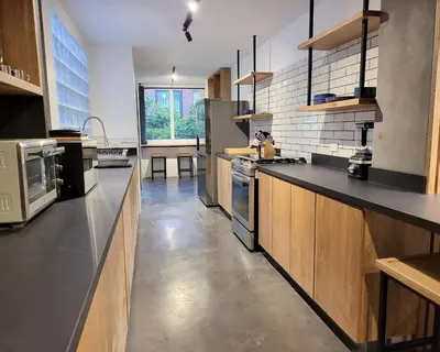 a large kitchen with black counter tops and wooden cabinets at Center City Flats - Apartments in El Poblado near Park Lleras, Medellin! in Medellín