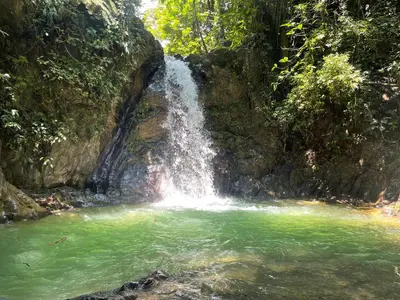 a waterfall in the middle of a pool of water at Cabañas Camino al Agua - Cocorná in Cocorná