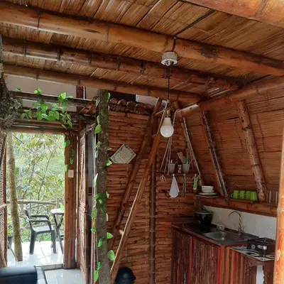 a kitchen with a wooden wall and a staircase in a house at Cabañas Camino al Agua - Cocorná in Cocorná
