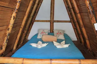 a room with a bed in a bamboo house at Cabañas Camino al Agua - Cocorná in Cocorná