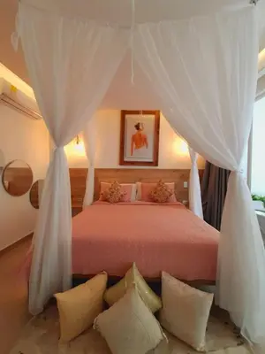 a bedroom with a bed with white curtains and pillows at Hotel Monte Bello in Doradal