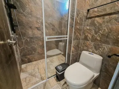 a bathroom with a toilet and a shower at Hotel Monte Bello in Doradal
