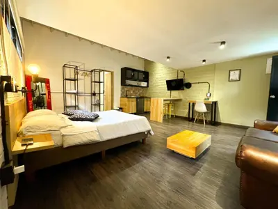a bedroom with a bed and a living room at FRN101 Cozy loft located in a popular in Poblado By Roots Rentals in Medellín