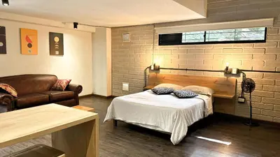a room with a bed and a chair and a couch at FRN101 Cozy loft located in a popular in Poblado By Roots Rentals in Medellín