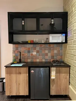 a kitchen with black cabinets and a black refrigerator at FRN101 Cozy loft located in a popular in Poblado By Roots Rentals in Medellín