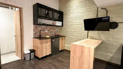 a kitchen with a tv on a brick wall at FRN101 Cozy loft located in a popular in Poblado By Roots Rentals in Medellín