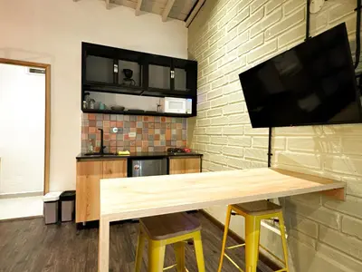 a living room with a wooden table and a flat screen tv at FRN101 Cozy loft located in a popular in Poblado By Roots Rentals in Medellín