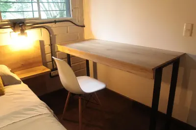 a room with a desk and a chair next to a bed at Apartamento en el Poblado, permite mascota FRN102 By Roots Rentals in Medellín