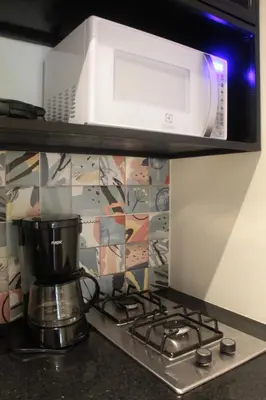 a microwave above a stove with a coffee maker at Apartamento en el Poblado, permite mascota FRN102 By Roots Rentals in Medellín