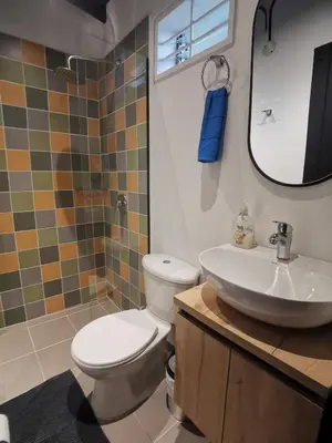 a bathroom with a toilet and a sink and a mirror at Apartamento en el Poblado, permite mascota FRN102 By Roots Rentals in Medellín