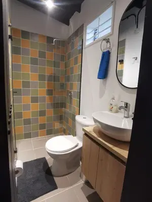 a bathroom with a toilet and a sink and a mirror at Apartamento en el Poblado, permite mascota FRN102 By Roots Rentals in Medellín
