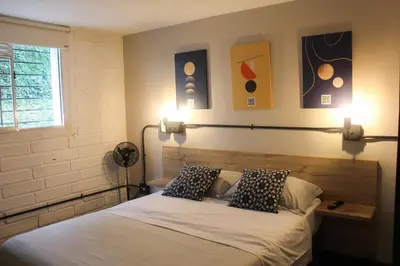 a bedroom with a bed with two pillows on it at Apartamento en el Poblado, permite mascota FRN102 By Roots Rentals in Medellín