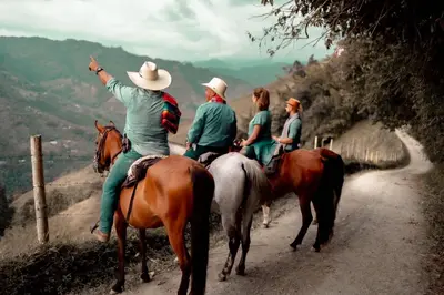 a group of people riding horses on a dirt road at Chamí Glamping in Manizales