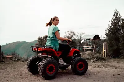 a girl riding a four wheeler on a dirt road at Chamí Glamping in Manizales