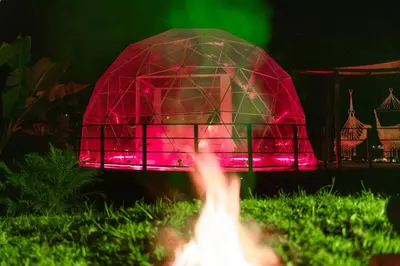 a red umbrella over a fire in the grass at Chamí Glamping in Manizales
