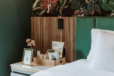 a bedroom with a bed and a nightstand with a box of candles at Selvario 36 Hotel in Medellín