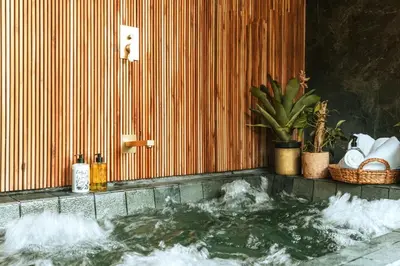a bathroom with a tub with water in it at Selvario 36 Hotel in Medellín