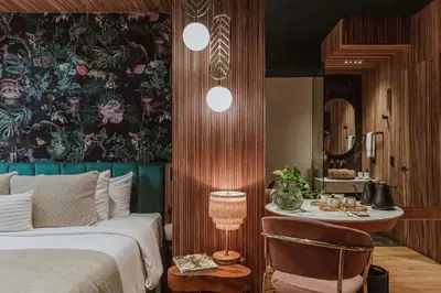 a bedroom with a bed and a table and a mirror at Selvario 36 Hotel in Medellín