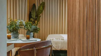 a room with a bed and a table with flowers at Selvario 36 Hotel in Medellín