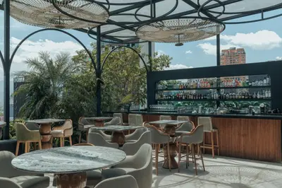 a restaurant with tables and chairs and a bar at Selvario 36 Hotel in Medellín