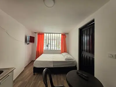 a small bedroom with a bed and a table at Apartaestudio1 Amoblado sector Cable Estadio in Manizales