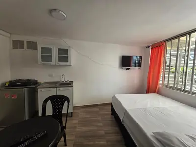 a room with a bed and a table and a kitchen at Apartaestudio1 Amoblado sector Cable Estadio in Manizales