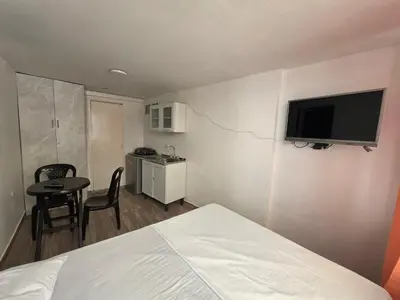 a bedroom with a bed and a television on the wall at Apartaestudio1 Amoblado sector Cable Estadio in Manizales