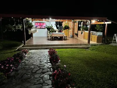 a patio at night with a table and some flowers at finca Encanto in Guarne