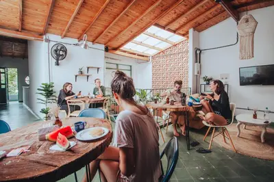 a group of people sitting at tables in a restaurant at Centro Hostel Medellin in Medellín